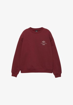 Bordó színű, hosszú ujjú, kerek nyakú pulóver, fehér felirattal a mellrészen, amely így szól: "Los Angeles Riverside / California P&B."