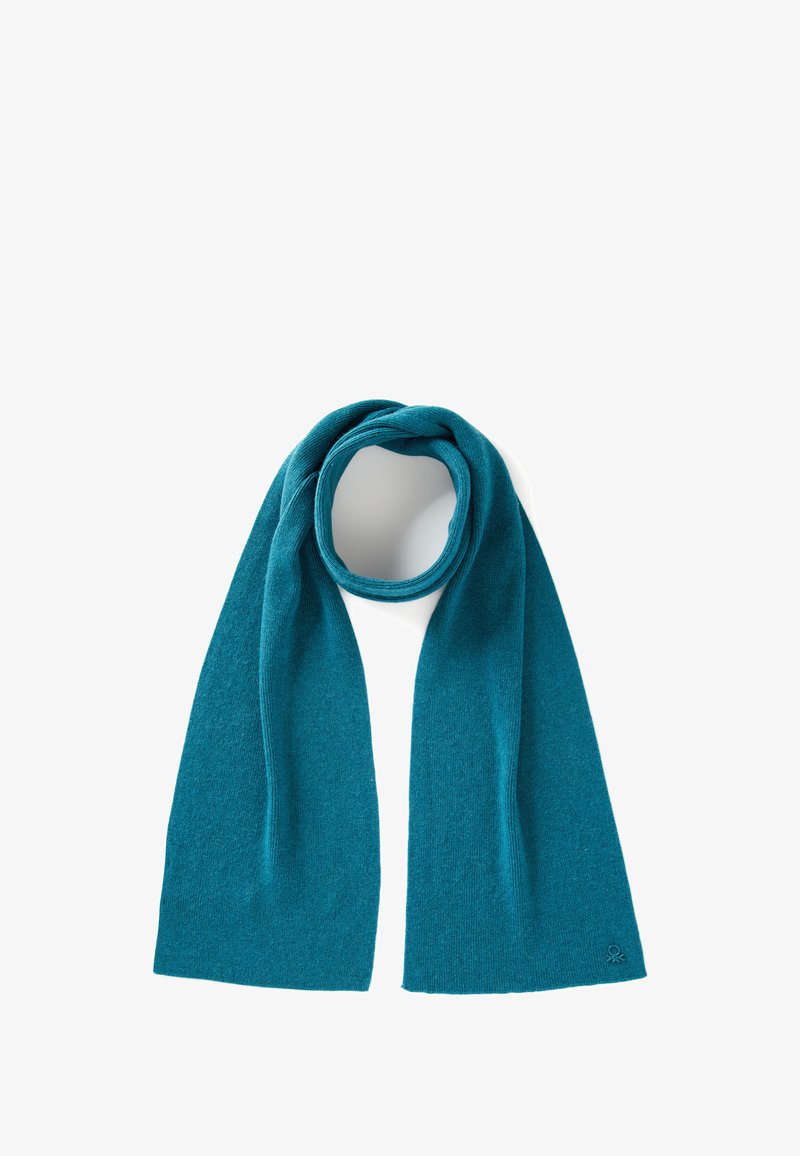 Bufanda de lana color teal con una textura suave, forma rectangular larga y bordes terminados. Acento de logotipo notable cerca de la esquina inferior derecha.