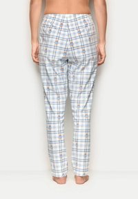 Tjekkede pyjamasbukser i hvid, blå og gul med bjørnemønstre. Har elastisk talje og et lige ben-design. Glat stoftekstur.