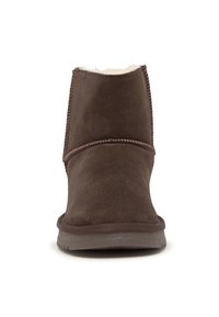 Botines de gamuza marrón con un suave forro interior, punta redondeada y costuras reforzadas a lo largo de los lados. Suela de goma plana.