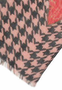 Pink and black scarf featuring a houndstooth pattern, with frayed edges. The fabric has a soft texture and visible fibers.