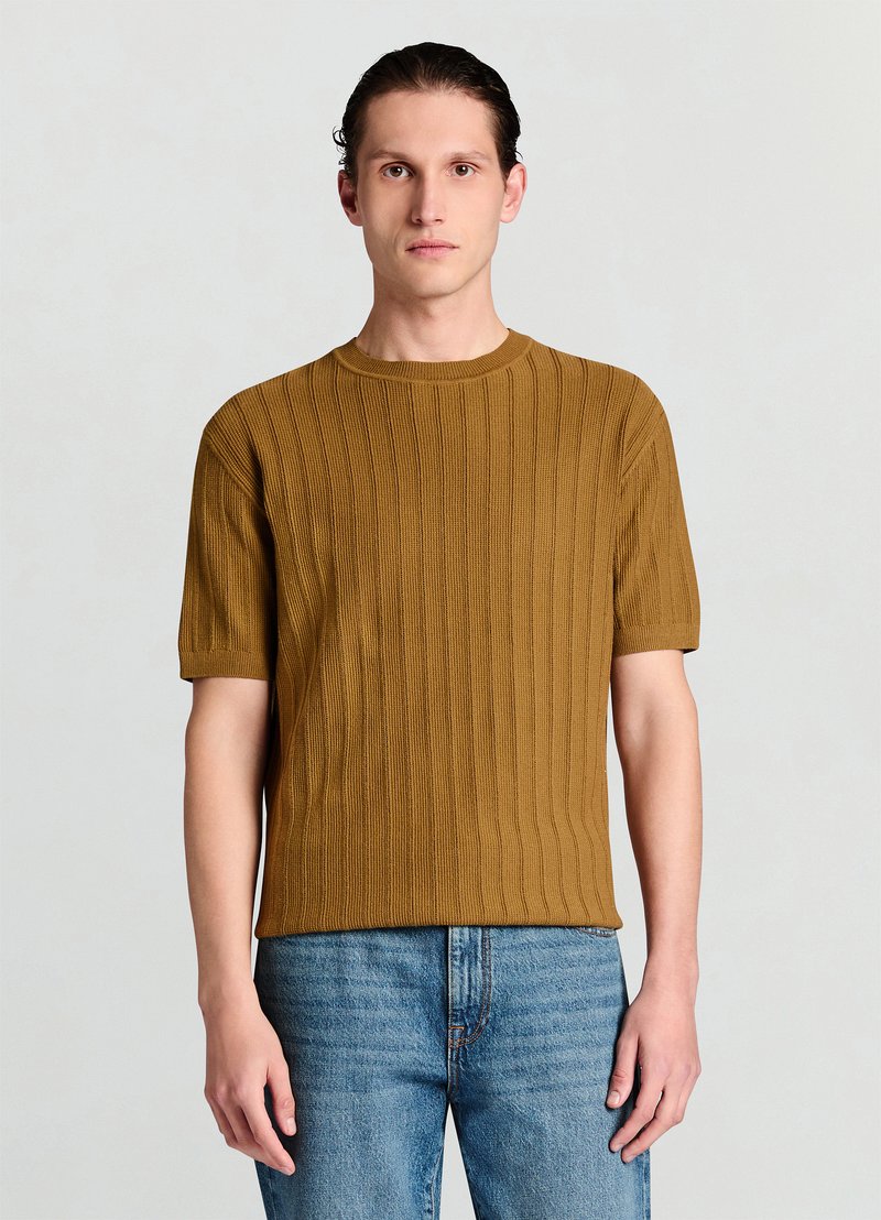 Mustard-colored knit t-shirt with short sleeves, featuring a vertical ribbed pattern and a crew neckline, paired with blue jeans.