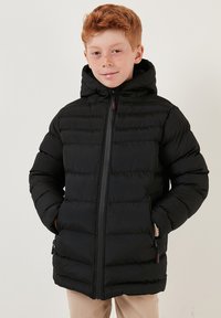 Zwarte pufferjas met capuchon, ritssluiting, horizontale stiksels en zijzakken. Glad, geïsoleerd materiaal voor warmte.