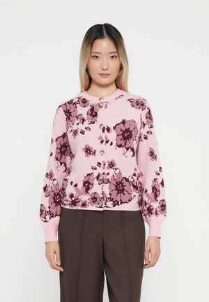 Rosa blomster mønstrede genser med lange ermer, rund hals og knapfront. Stoffet ser mykt ut med en avslappet passform.