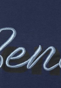 Navy Baumwollstoff T-Shirt mit gesticktem, hellblauen Schriftzug. Der Hintergrund hat ein einfarbiges schwarzes Muster hinter den Buchstaben.