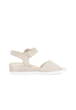 Sandale compensée beige avec bout ouvert, bride de cheville réglable et semelle intermédiaire texturée, conçue pour un usage décontracté ou habillé.