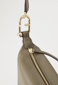 Borsa in pelle verde oliva con hardware dorato, dotata di una cerniera visibile e di una tracolla staccabile. Texture liscia e forma curva.