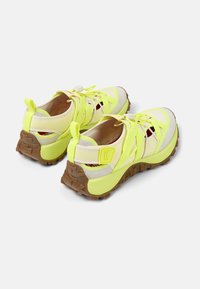 Sporty sneakers with a neon yellow upper, beige accents, and textured brown outsole. Features adjustable laces and a cushioned interior.