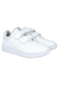 Zapatillas deportivas blancas con parte superior de cuero liso, dos correas de Velcro, área de punta perforada y suela de goma blanca texturizada.