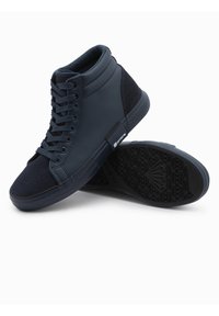Zapatillas altas de marino hechas de cuero suave y ante con una suela de goma texturizada y cordones planos. Incluye una etiqueta de marca en el costado.