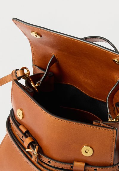 Sac à main en cuir marron avec rabat ouvert, fermoirs magnétiques dorés, sangle réglable avec boucle, et doublure intérieure noire.