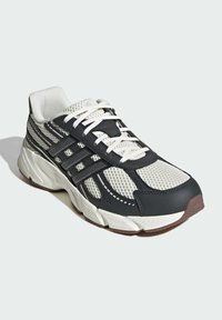 Športové tenisky s hornou časťou z mesh a syntetického materiálu v námorníckej modrej a bielej farbe, s posilnenými detailmi, plochými šnúrkami a polstrovanou podrážkou.