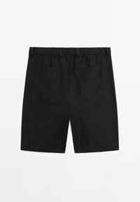 Pantaloni corti neri in lino con vita elasticizzata, dotati di due tasche posteriori e una texture liscia, progettati per il comfort e la traspirabilità.