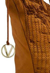 Braune Lederhandtasche mit strukturierten Schuppen, glatten Seiten und einem runden Metalletikett mit der Gravur "Venezia". Kordelzugverschluss oben.