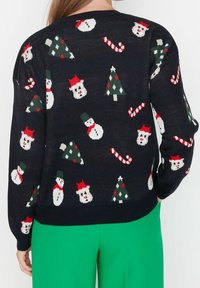 Granatowy sweter dziany z świątecznymi wzorami: bałwanki, choinki i laski cukrowe w czerwonych, białych i zielonych odcieniach. Luźny krój, ściągacz na dole.