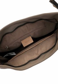 Brown leather handbag interior with smooth fabric lining, featuring one zip pocket and two open compartments, all with a dark zipper.