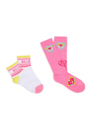 Deux paires de chaussettes, une courte blanche avec des accents jaunes et roses et le texte "BILLIE", une longue rose avec des motifs colorés en forme de cœur.