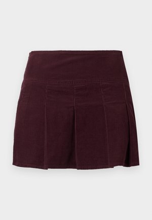 Donkerpaarse corduroy rok met brede tailleband en gestikte plooien aan de voorkant en zijkanten, weergegeven op een effen witte achtergrond.