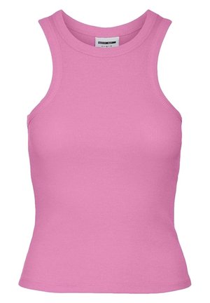 Woman wearing a sleeveless pink top, loose pink pants, and beige fuzzy slippers, standing against a plain white background.