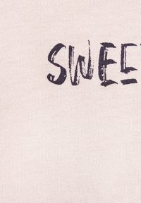 Light pink fabric with a soft texture featuring dark, unevenly drawn text spelling "SWEET" in a bold, playful font.