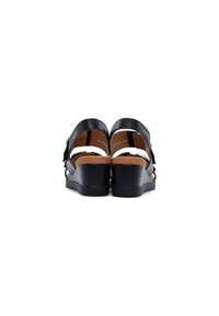 Sandali con zeppa nera, upper in pelle, con apertura sul retro e cinghie laterali, soletta imbottita marrone e suola in gomma testurizzata.
