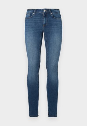 Skinny jeans in donkerblauwe denim, met vijf zakken, een knoopsluiting en een rits. De stof heeft een gladde textuur met een lichte vervaging.
