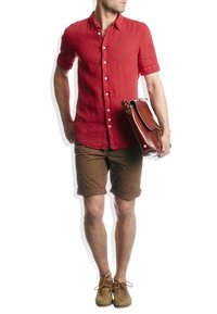 Rood linnen overhemd met korte mouwen, bruine gerolde shorts, bruine leren tas en lichtbruine schoenen met veters. Eenvoudige, casual outfit.