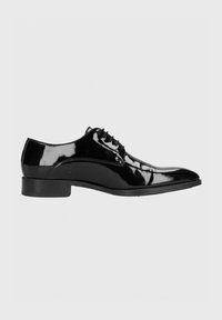 Zwarte gepatineerde leren oxford schoen met een spitse neus, vetersluiting en een lage hak. Gladde, glanzende afwerking met minimale stikseldetails.