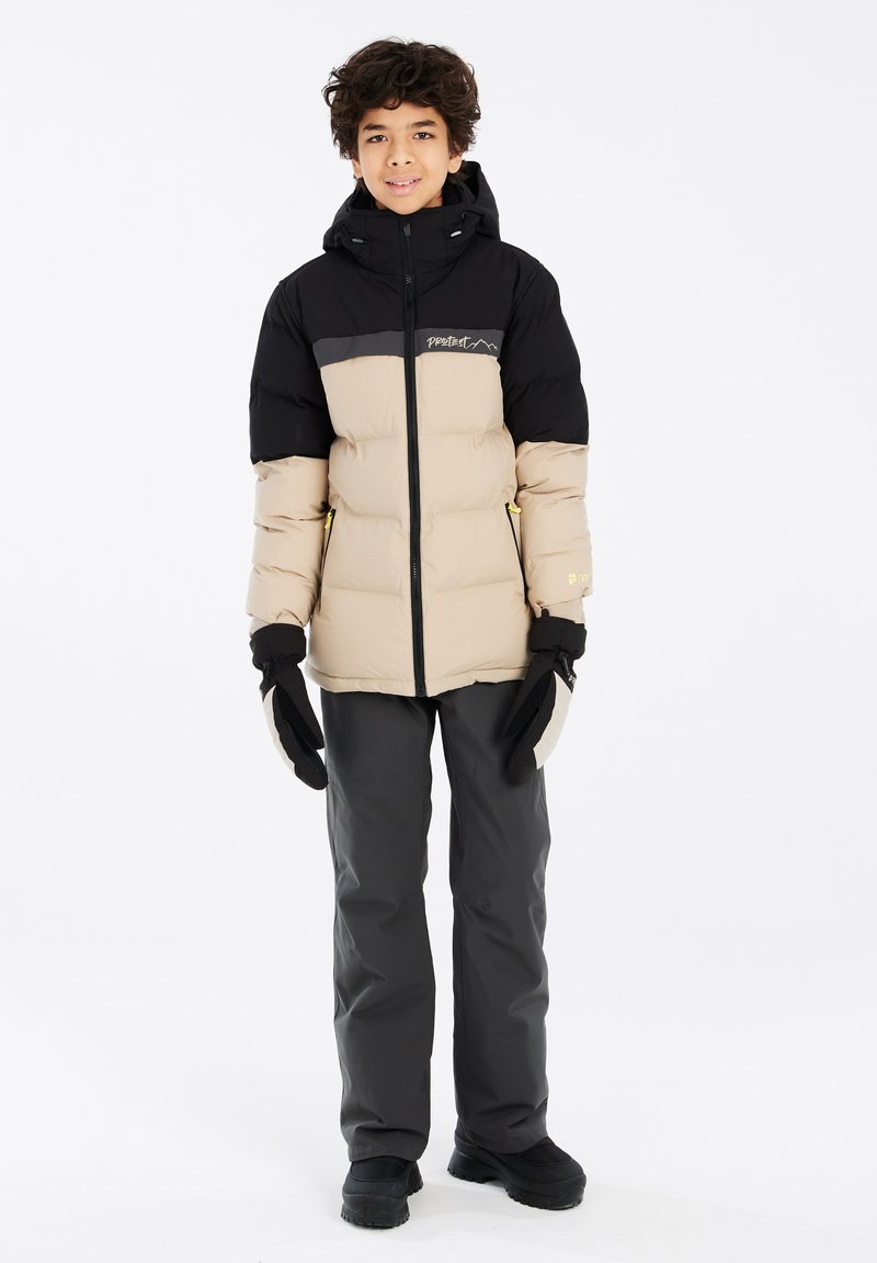 Giacca imbottita nera e beige con zip frontale, cappuccio e logo. Abbinata a pantaloni grigio scuro e guanti, tutti adatti per il freddo.