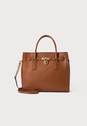 Sac à main en cuir marron avec deux poignées, un détail de serrure dorée au centre et une bandoulière amovible avec une chaîne dorée sur un côté.