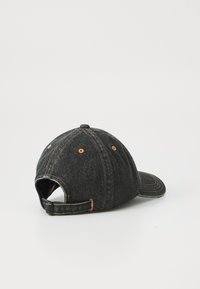 Boné de denim preto com aba curva, costura laranja, tira ajustável e seis buracos de ventilação. A textura parece suave e durável.