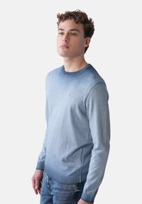 Helles blauer Gradient-Pullover mit rundem Ausschnitt, aus weichem Material gefertigt. Verfügt über gerippte Bündchen und Saum sowie dezente Steppdetails.