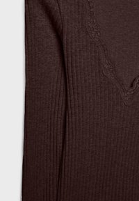 Brunt ribbet stof med en fin blondestrimle langs udskæringen, med en subtil tekstur og en tætsiddende pasform.