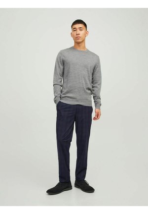 Maglione grigio a maniche lunghe, pantaloni a scacchi blu navy e scarpe nere. Il tessuto appare liscio; l'outfit presenta un design semplice e classico.