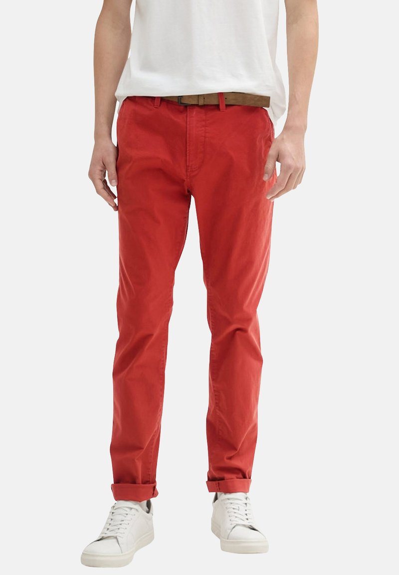 Chinos en coton rouges avec une coupe slim, des ourlets retroussés et un design à plat. Associés à des baskets blanches pour un look décontracté.