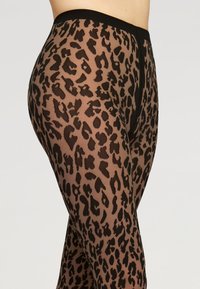 Gennemsigtige leggings i et sort og brunt leopardprint, med en bred sort talje og en glat, struktureret overflade.