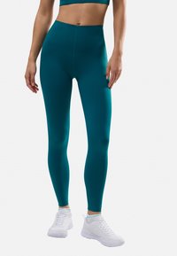 Leggings de talle alto en tono azul verdoso, fabricados con un tejido suave y elástico. Presentan un diseño ajustado, construcción sin costuras y una silueta limpia y moderna.