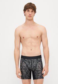 Μαύρες και γκρίζες boxer briefs με σχέδιο, έχοντας μία ενιαία μαύρη ζώνη μέσης. Ελαστικός ιστός με λείο υφή και εφαρμοστή σχεδίαση.