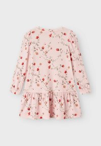 Robe rose à manches longues en tissu doux, dotée d'un imprimé floral avec des accents rouges et verts, des manches froncées et un ourlet en cascade.