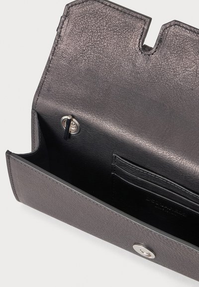 Portefeuille en cuir gris foncé ouvert avec rabat texturé, fermeture à pression métallique et emplacements noirs pour cartes à l'intérieur.