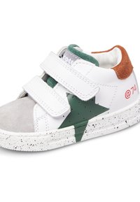 Sneaker bianca con accenti in suede grigio, design a stella verde e tacco marrone. Dispone di due cinturini in Velcro regolabili e una suola bianca maculata.