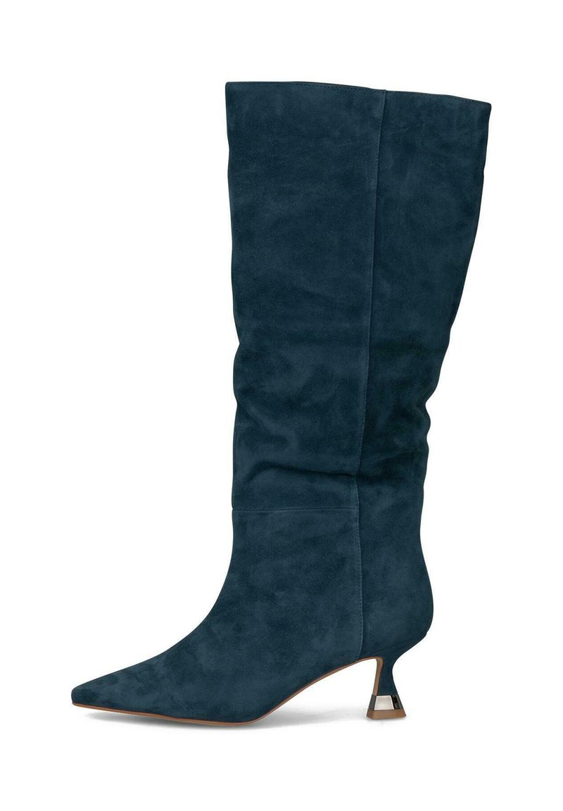 Bota de ante azul oscuro hasta la rodilla con punta afilada y un tacón corto y curvado que presenta un acento metálico. Textura suave con un diseño fruncido.