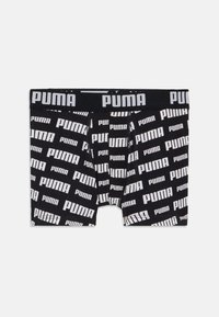 Schwarze Boxershorts mit einem sich wiederholenden weißen "PUMA"-Logo-Muster auf dem Stoff und einem einfarbigen schwarzen Bund.