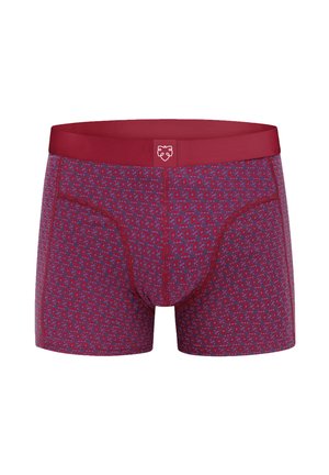 Férfi piros boxeralsó kék geometriai mintával és egyszínű piros derékpánttal, közepén fehér oroszlánarc logóval.