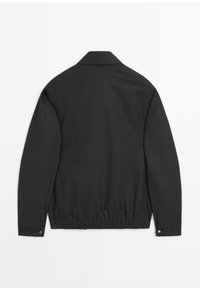 Veste noire à manches longues avec col, taille élastique et boutons-pression aux poignets, vue de dos sur fond blanc.