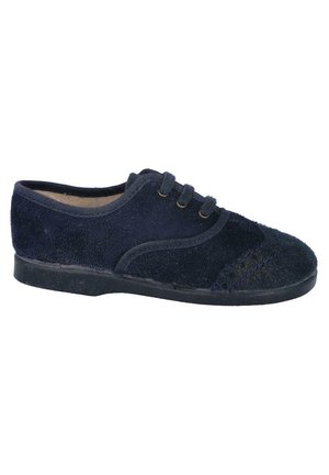 Zapato de ante azul marino con un perfil bajo, punta redondeada, dos ojetes y costuras en contraste en la punta y los laterales. Suela de goma.