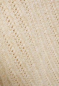 Tessuto lavorato a maglia color crema con un motivo a chevron in pizzo e sottili fili metallici dorati intrecciati.