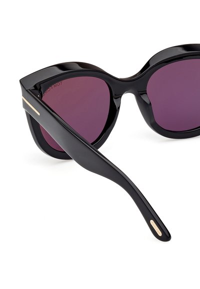 Svarta cat-eye solglasögon med lila linser, glänsande plastbåge och en subtil gulddetalj vid skalmarna.