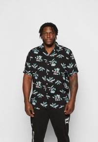 Black short-sleeve shirt with vibrant floral pattern in white, aqua, and burgundy; features button-down front and a relaxed fit.