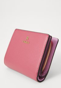 Portefeuille en cuir rose avec une texture granuleuse, logo doré et une poche à pièces zippée. Présente un intérieur violet contrastant et des bordures noires.